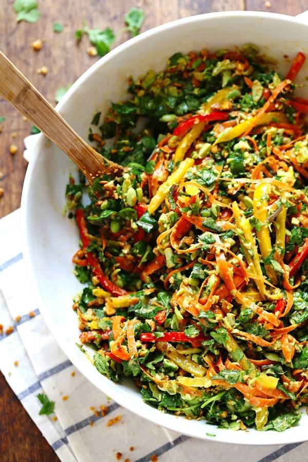 Chopped Thai Salad with Sesame Garlic Dressing in a white bowl with a wooden spoon.