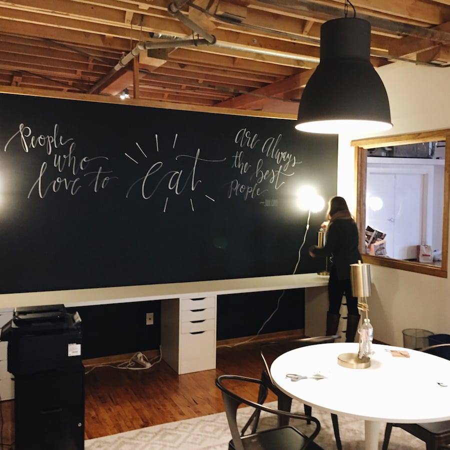 A person in front of a large blackboard in a room.