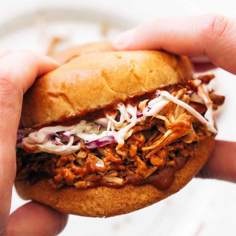 A person holding a jackfruit sandwich.