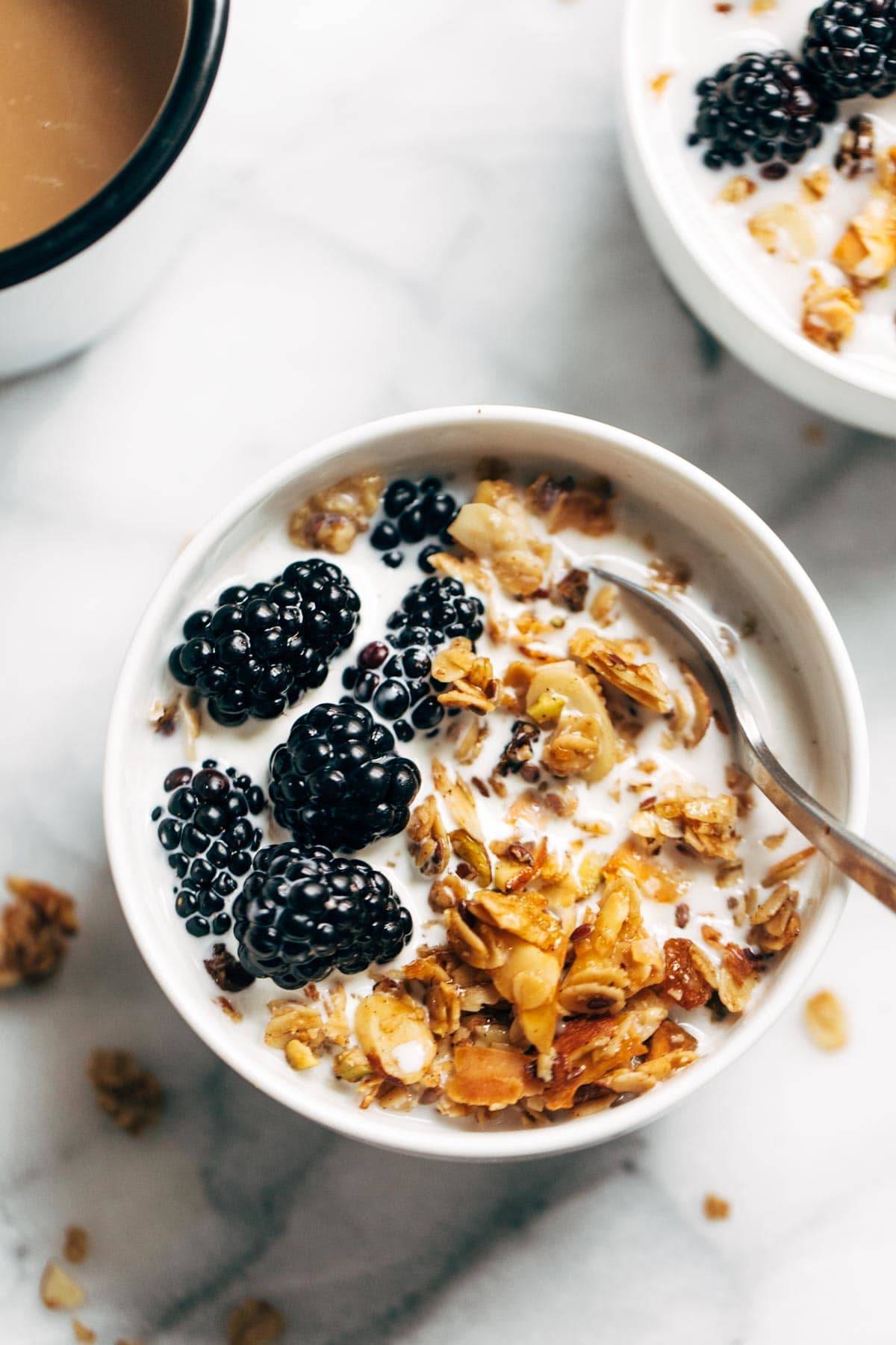 Coconut oil granola in bowl with milk and berries.