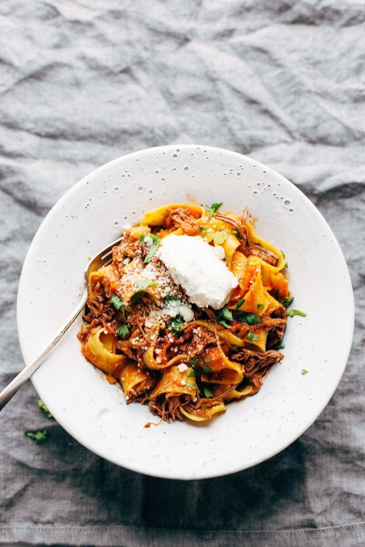 Beef ragu with pappardelle in a bowl with a fork. 