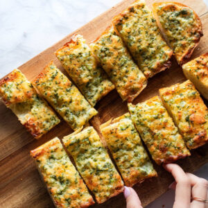 Garlic bread slices on a cutting board.