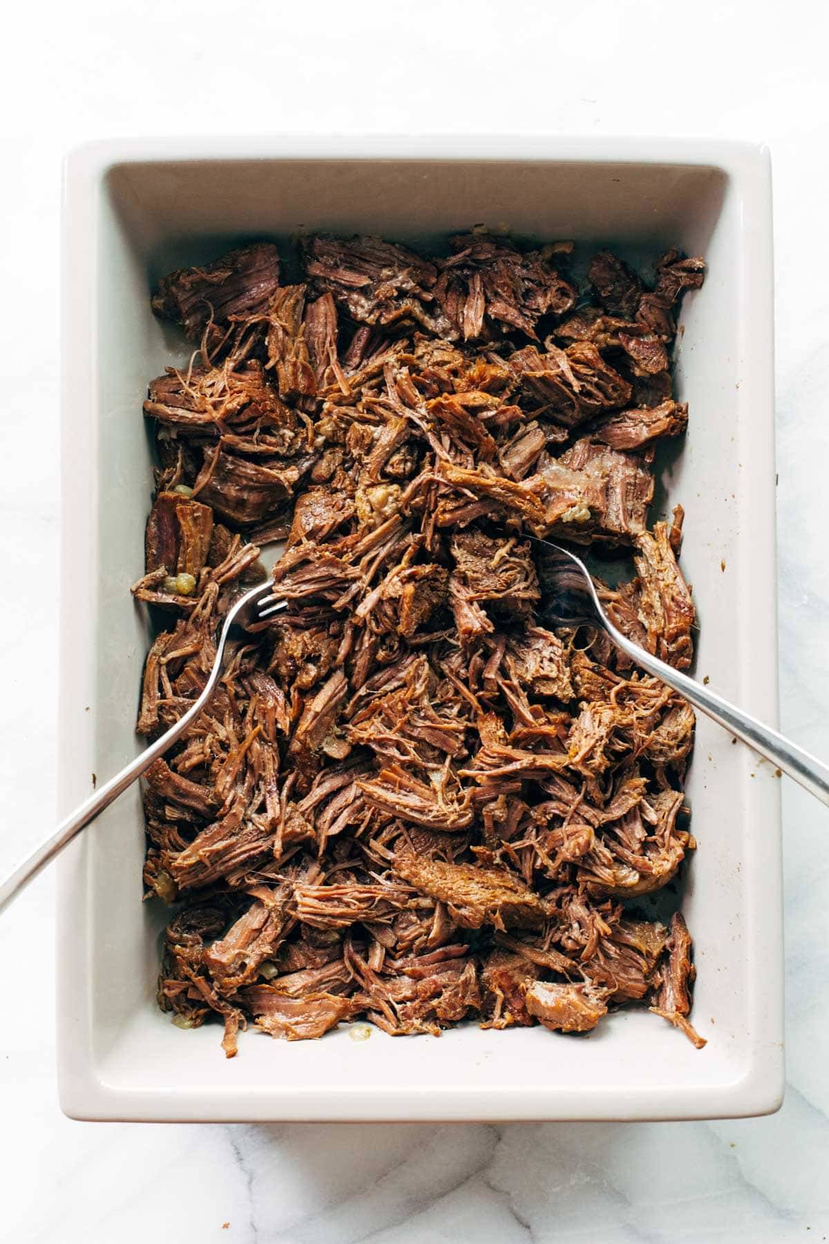 Italian beef shredded in a pan.