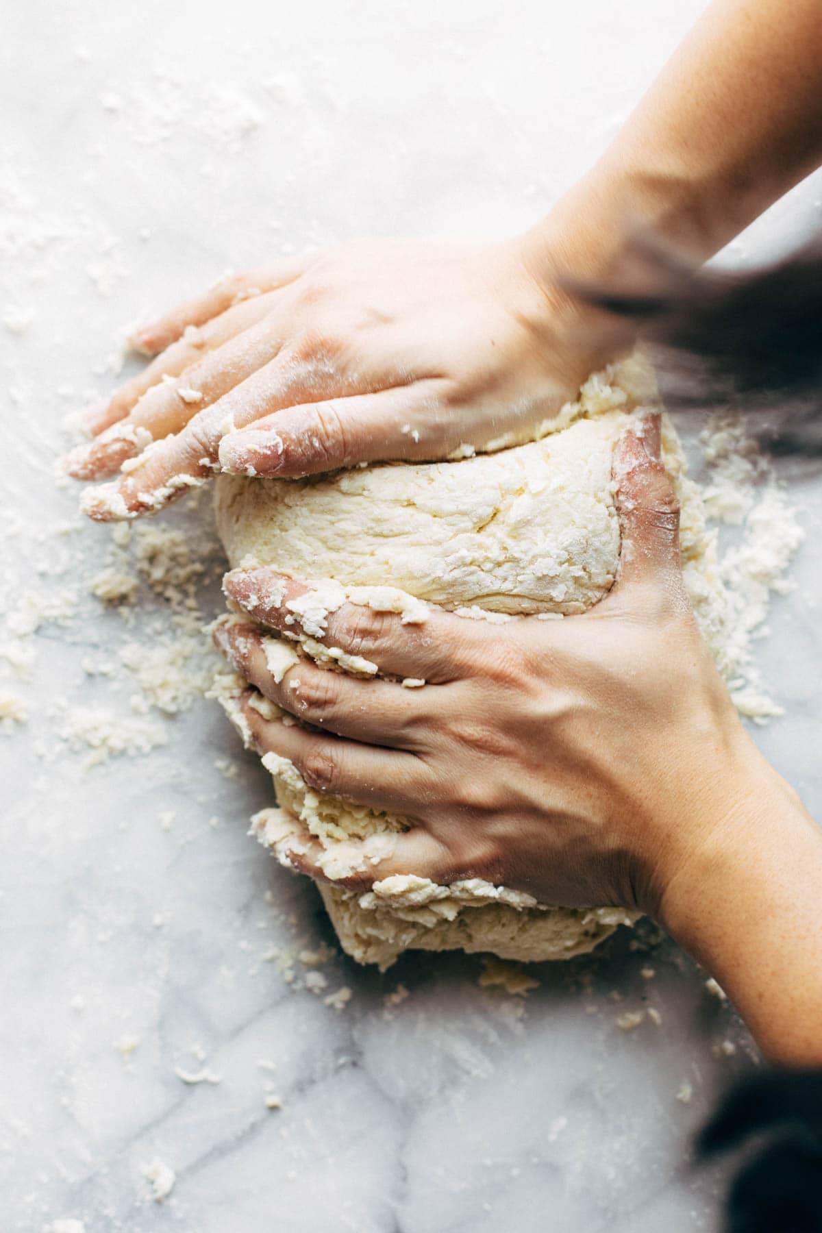 Hands kneading gnocchi dough.