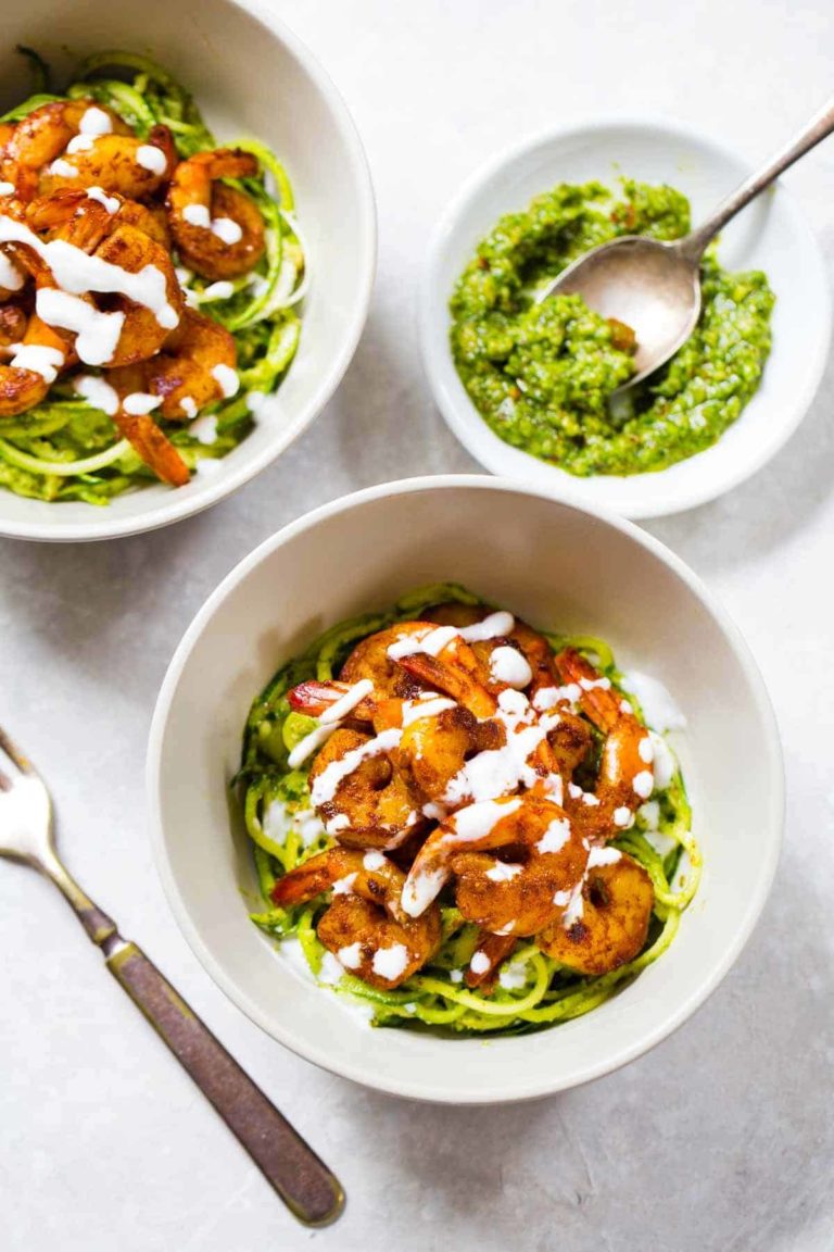 Two bowls havewith shrimp next to sauce.