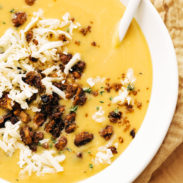 Pumpkin soup in a bowl with walnut crispies and a spoon!