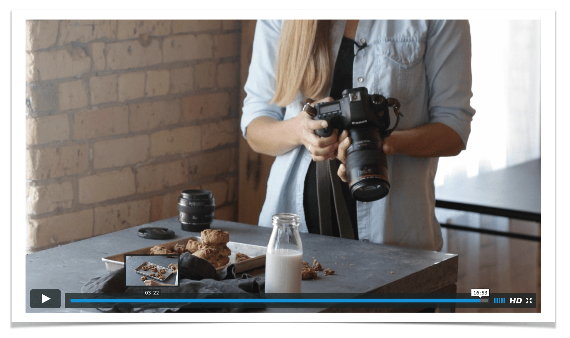 Still shot of a woman holding a camera.