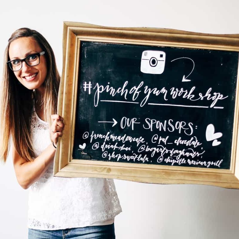 Lindsay holding a chalkboard for the Tasty Food Photography workshop.