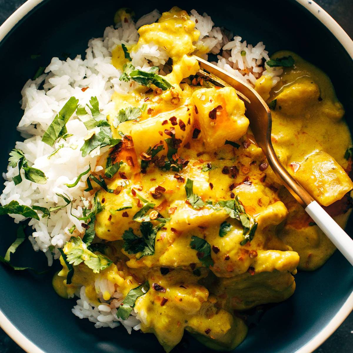 Yellow curry in a bowl with rice and a fork