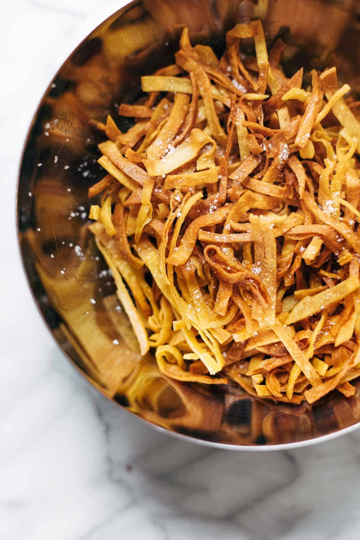 Fried tortilla strips in bowl.