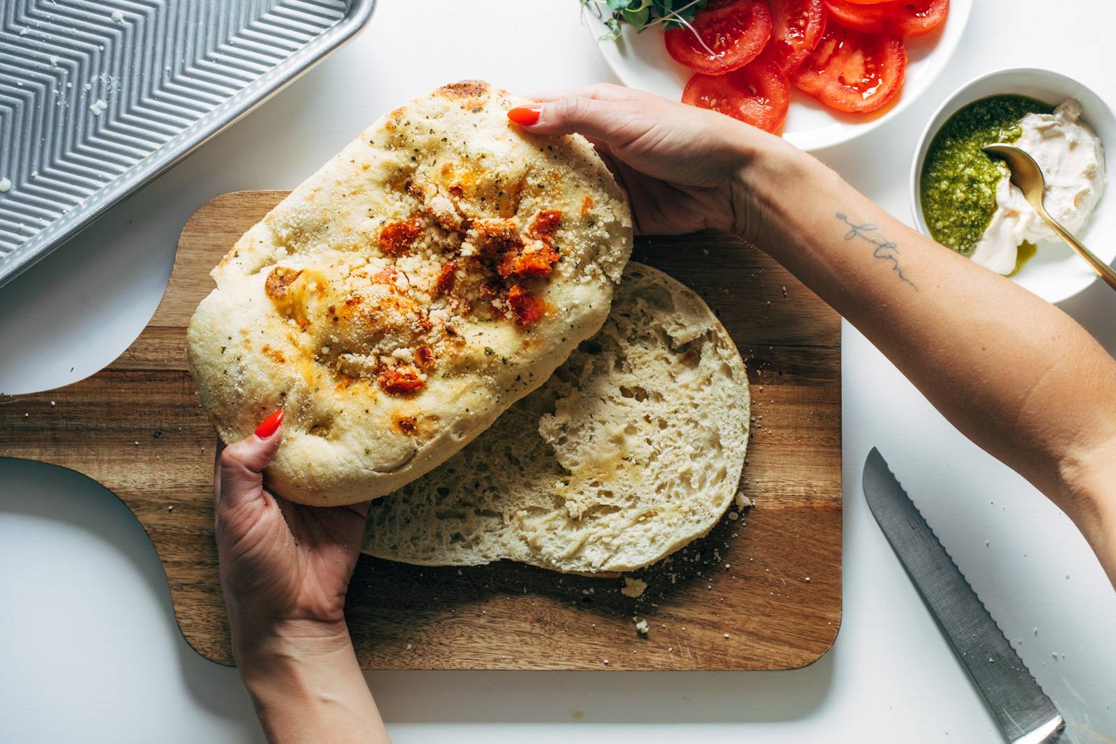 White hand moving a piece of focaccia bread